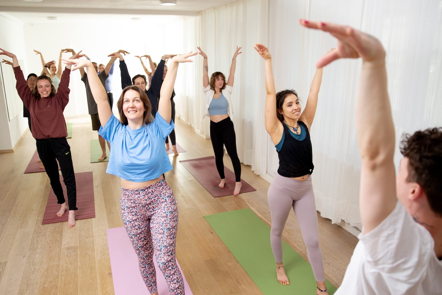 Yoga Dance Flow Teilnehmende beim Tanz mit erhobenen Armen