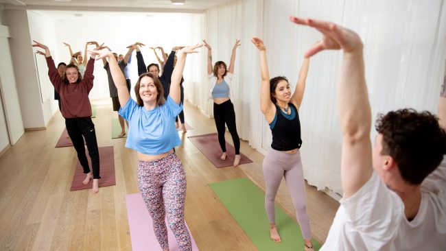 Yoga Dance Flow Teilnehmende beim Tanz mit erhobenen Armen