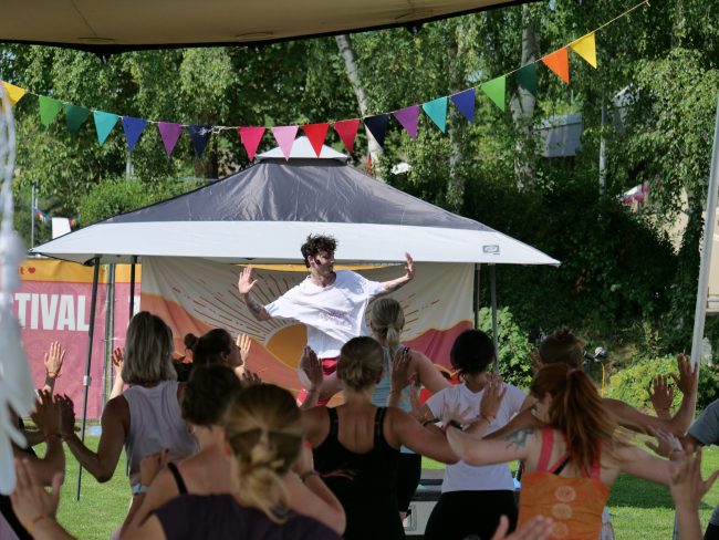 Joschua Taake Yoga Dance Flow Lehrer vor einer Yoga Dance Flow Gruppe beim Yoga Festival